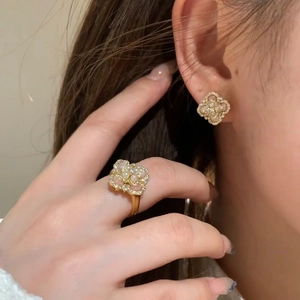 Elegant gold four-leaf clover jewelry set with pearls and zircons on a model