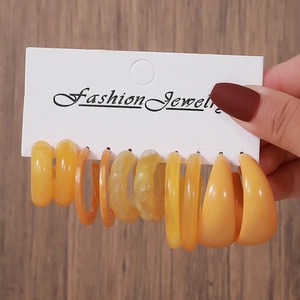 Set of amber and yellow acrylic hoop earrings displayed on a fashion jewelry card