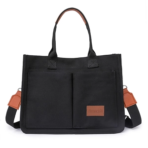 Minimalist black canvas tote bag with brown leather handles and large front pockets