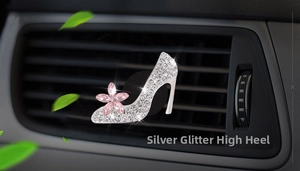 Close-up of sparkling diamond high heel perfume clip on car air vent in silver and pink