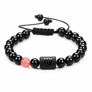 Detail of adjustable black obsidian Virgo constellation bracelet with a pink accent bead