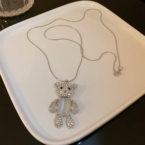 Macro shot of silver bear necklace featuring shiny rhinestones and opal stone inlay