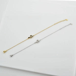 Detail of gold and silver S925 sterling silver snake bracelets with zircon pavé and charms