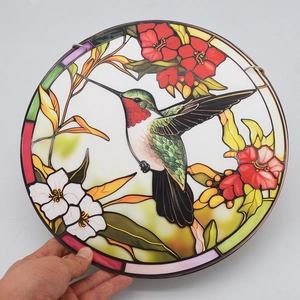 Translucent stained glass hummingbird and floral window hanging with metal frame detail