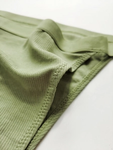 Macro view of fine ribbed cotton stitching and soft sage green fabric texture
