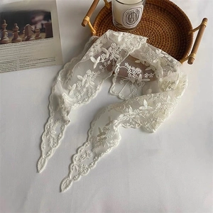 Detailed macro of white floral lace headband with scalloped edges in French vintage style