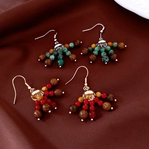 Détail des boucles d'oreilles ethniques avec perles en bois et touches turquoise