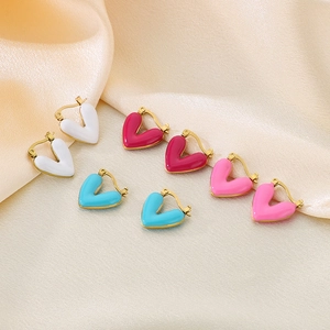 Colorful heart-shaped enamel hoop earrings in gold finish on beige silk background