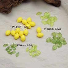 Flat lay of yellow resin lemon charms and green leaf pendants for DIY jewelry making