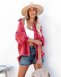 Detail of red oversized denim jacket with distressed frayed hem and casual street style