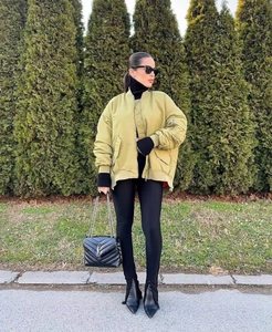 Detail of olive green oversized bomber jacket with ribbed cuffs and sleeve zipper pocket