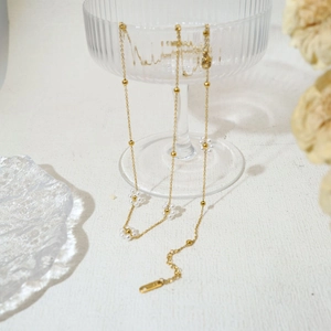 Elegant gold flower pearl necklace set with floral accents on a textured background
