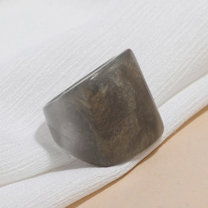 Detailed macro view of gray resin ring with marble texture and gold powder flecks