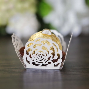 Close-up of white laser-cut rose hollow favor box with a chocolate interior detail