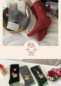 Close-up of Christmas knit socks with festive embroidery and holiday gift packaging