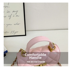 Detailed close-up of pink quilted crossbody bag with gold hardware and leather handle