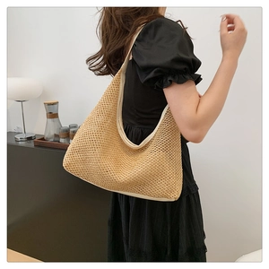 Close-up of khaki hand-woven tote bag showing intricate openwork straw texture