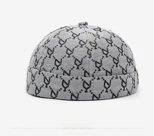 Dettaglio laterale del berretto docker grigio con motivo jacquard di lettere N nere