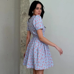 Vue de profil d'une robe fleurie française avec motifs roses sur tissu bleu clair et coupe slim