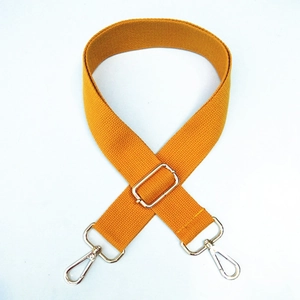 Detail of ginger yellow canvas bag strap with adjustable silver metal hooks and buckle
