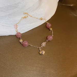 Elegant strawberry quartz heart bracelet with gold chain and shell charms on soft silk