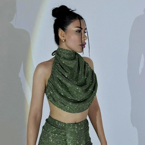 Detail of olive green sequined halter top and high-waist skirt set with shimmer texture