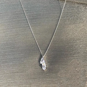Macro detail of S925 sterling silver necklace with double teardrop zircon pendants