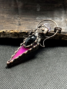 Detail of vintage bronze pendant featuring black onyx and pink agate with crystal point