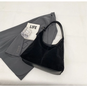 Detail of hobo shoulder bag featuring black suede and PU leather stitching texture