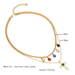 Detailed view of gold double layer necklace with colorful charms and cross pendant