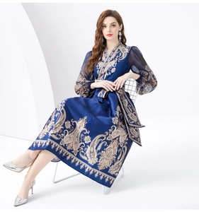 Close-up of deep blue V-neck wrap dress featuring gold baroque patterns and lantern sleeves