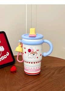 Detail of portable cartoon stainless steel coffee mug with handle on dark wooden desk