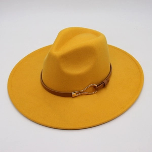 Detail of ginger yellow wool fedora hat featuring brown leather band and gold buckle