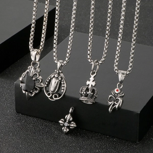 Detail of silver vintage crown and cross pendants with inlaid rhinestones on black display
