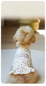 Detail of floral print pet dress showing sewing process and soft ruffled hem on a dog
