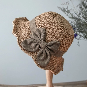 Close-up of woven straw texture and decorative ribbon bow on a summer sun hat