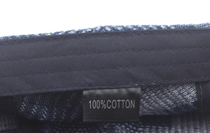 Detail view of the 100% cotton inner lining and label of a blue denim beret cap
