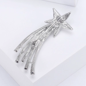 Macro shot of silver star brooch back showing secure pin clasp and sunburst texture