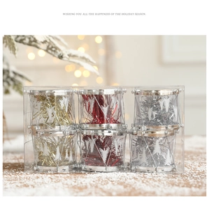 Festive Christmas drum ornaments in gold, red, and silver set on a snowy wooden surface