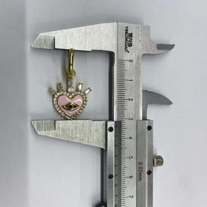 Detail shot of heart-shaped evil eye earring pendant measured with a caliper