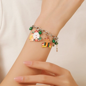 Detail of Christmas charm bracelet on wrist featuring Santa, reindeer, and bells