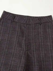 Détail du pantalon à carreaux gris foncé montrant la texture et la taille élastique
