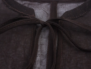 Detail of dark brown chiffon dress featuring a lace-up neckline and textured fabric