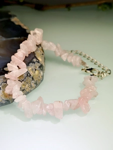 Macro shot of irregular pink quartz stone bracelet with silver metal extension chain