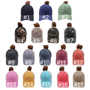 Collection of distressed ponytail baseball caps in solid colors, leopard print, and camo
