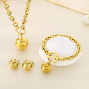 Detail of gold titanium jewelry set featuring ball pendants and toggle clasp closure