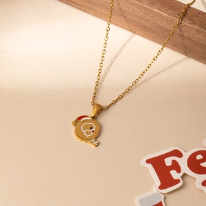 Detail of gold stainless steel necklace with enamel Christmas puppy pendant and festive props