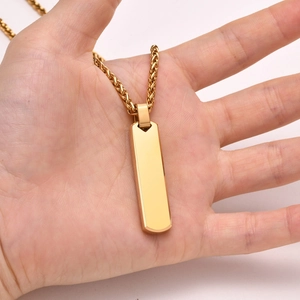 Detailed close-up of a golden rectangular pendant on a high-quality woven chain necklace