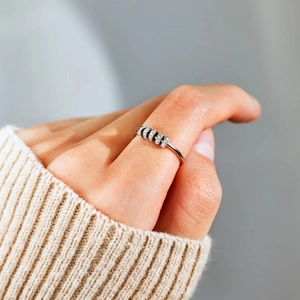 Close-up of S925 sterling silver anxiety ring with rotating colorful zircon beads on a finger