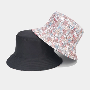 Detail of reversible bucket hats in solid black and colorful cartoon animal pattern cotton